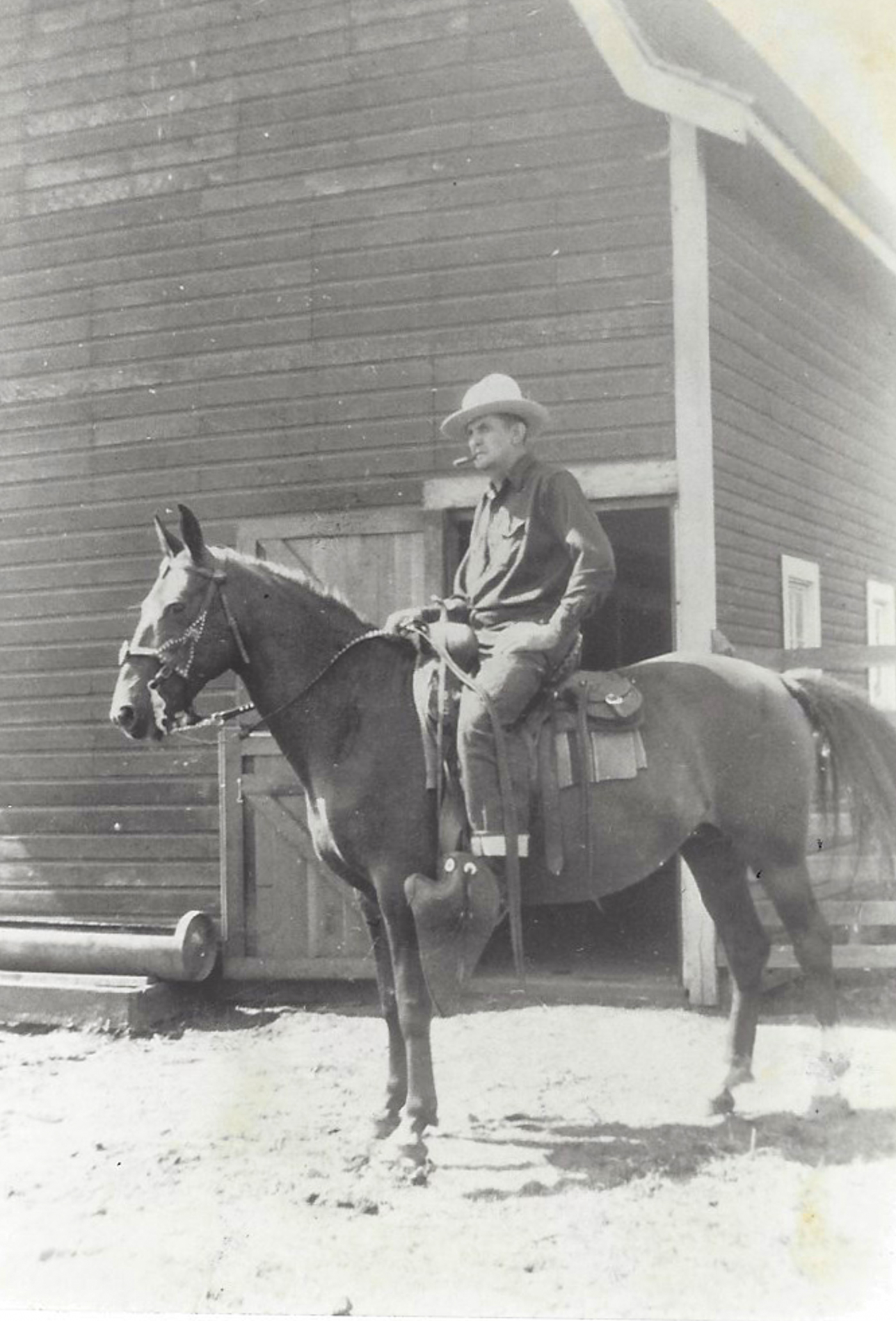 Horseback in front of barn.